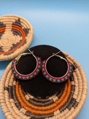 A close-up of the Painted Earth hoop earrings, detailing the intricate brick stitch pattern that contrasts vibrant turquoise beads against the warm, earthy tones of the design.