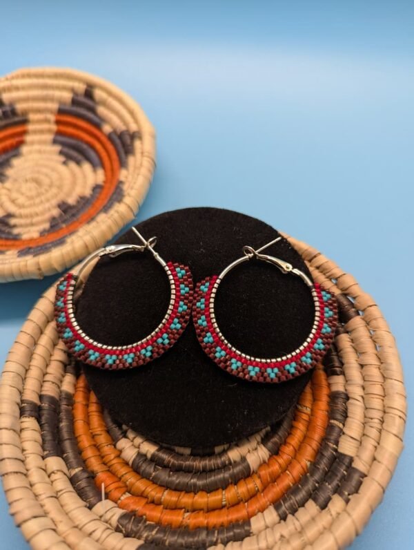 A Close-Up Of The Painted Earth Hoop Earrings, Detailing The Intricate Brick Stitch Pattern That Contrasts Vibrant Turquoise Beads Against The Warm, Earthy Tones Of The Design.